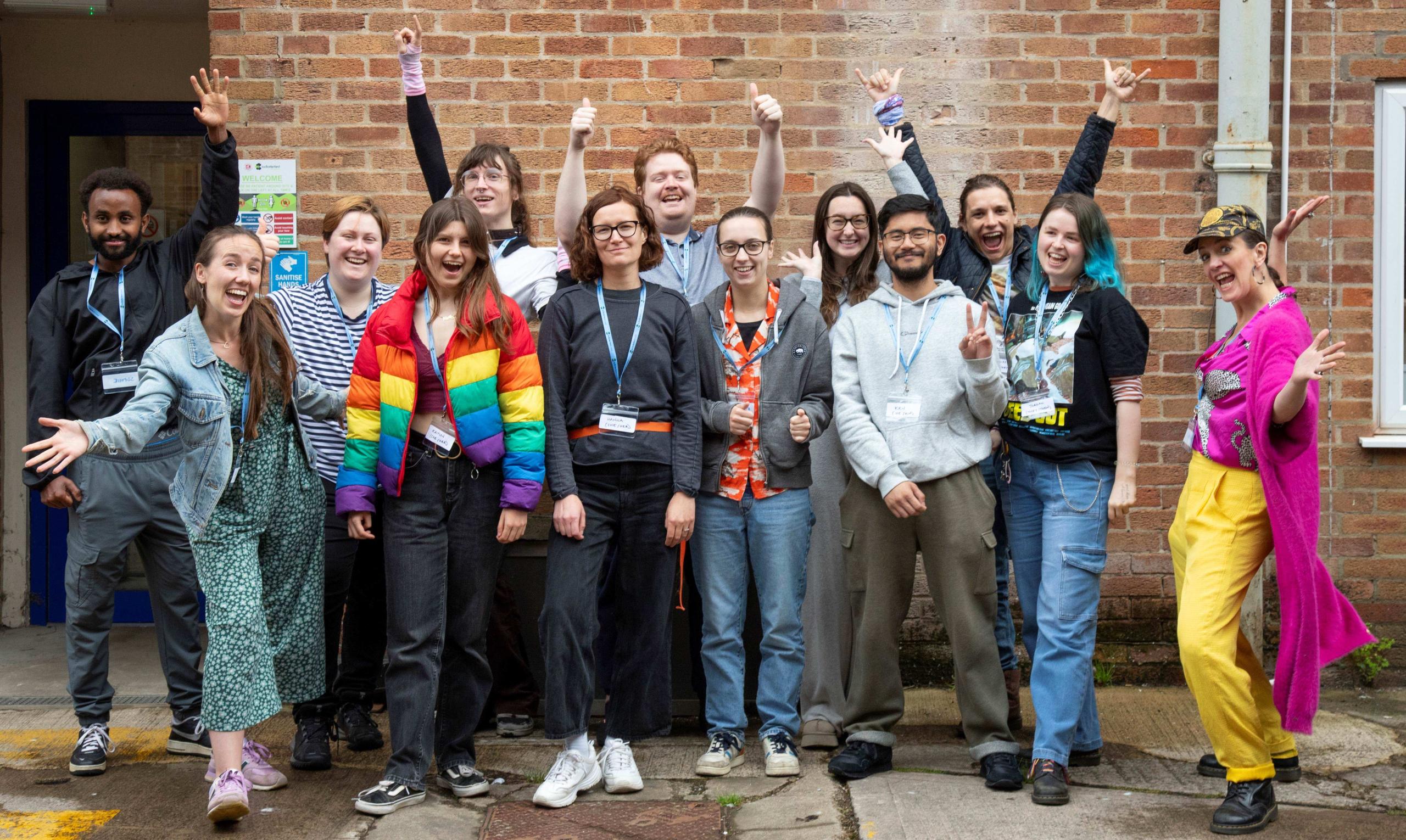 A group of people posing in front of a red brick wall